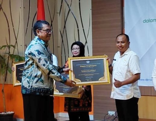 PENGHARGAAN: Kepala Diskopukmpp Hari Tri Santosa saat menerima penghargaan dari Kantor Pelayanan Kekayaan Negara dan Lelang (KPKNL) Bandung. (For Radar Sumedang)